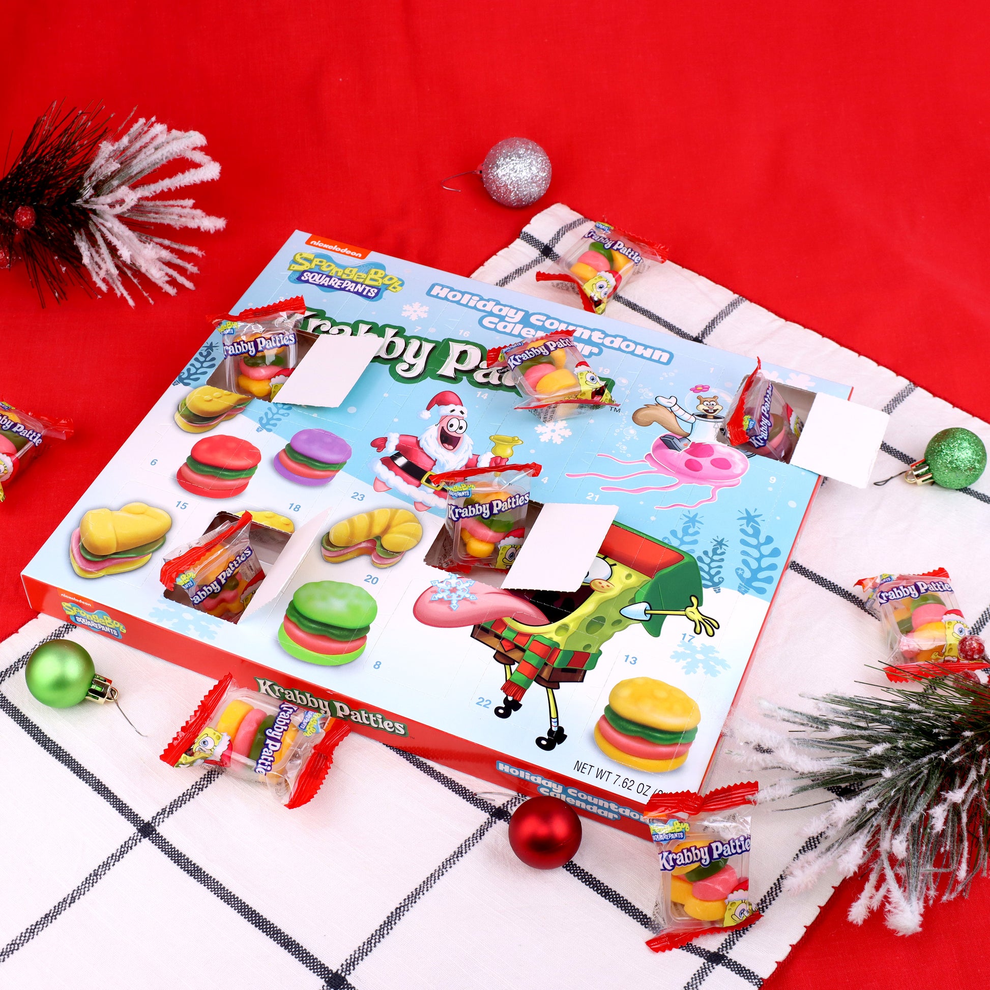 calendar with some dates opened showing individually wrapped krabby patties surrounded by christmas decorations and a red background 