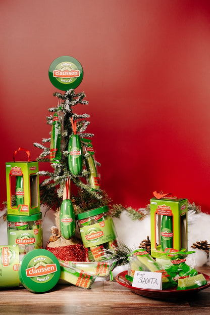 ornament packs and ornaments unwrapped with gummy pickle candy and a claussen christmas tree in the background 