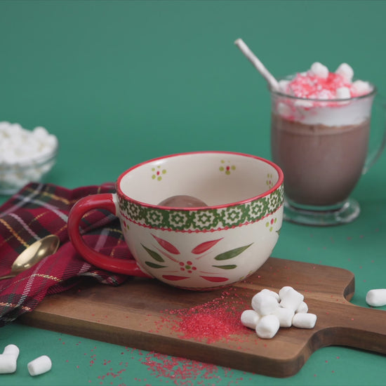 video showing milk pouring over a hot chocolate bomb in a mug