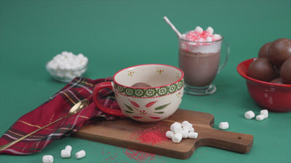 video showing milk pouring over a hot chocolate bomb in a mug