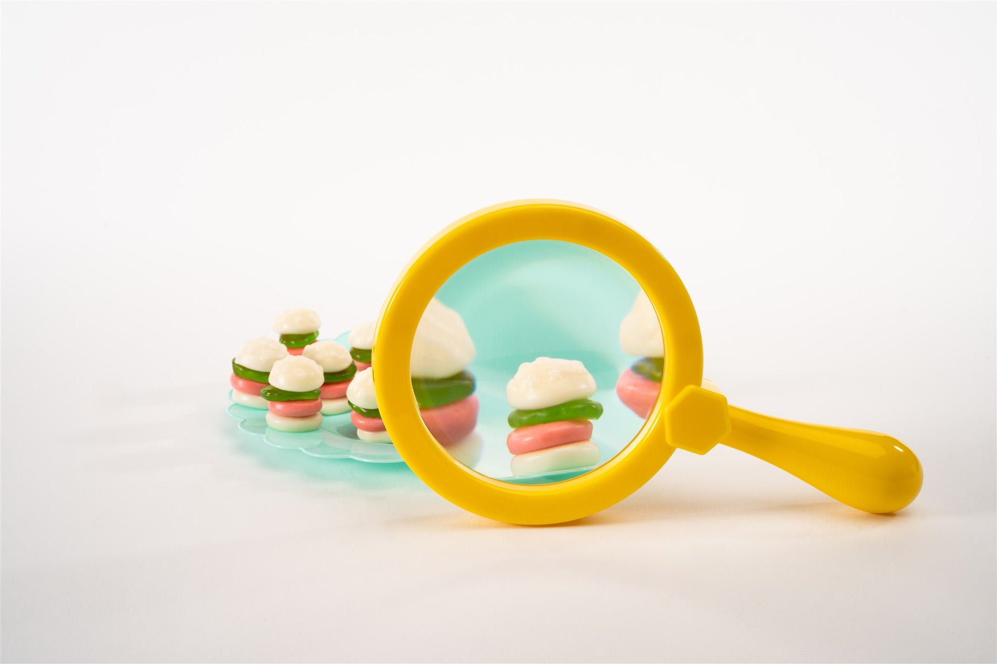 Unwrapped gummies on plate with magnifying glass